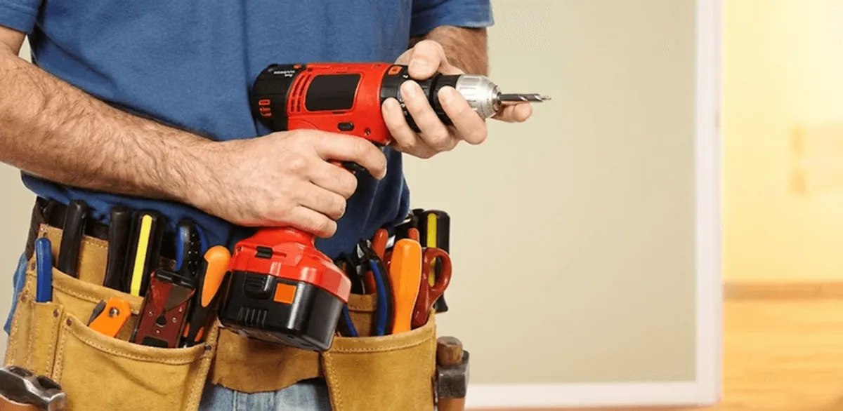Handyman holding a power drill for home repairs and installations in Aurora, IL